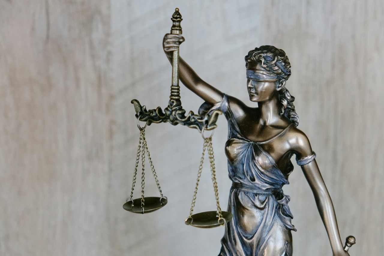 A bronze Lady Justice figure holding balanced scales